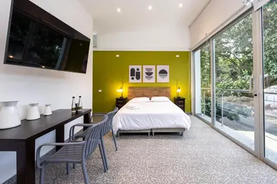 a bedroom with a bed and a desk and chairs at Contablers in Medellín