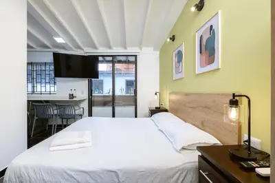 a bedroom with a large white bed and a table at Contablers in Medellín