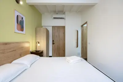 a bedroom with a large bed with white sheets at Contablers in Medellín