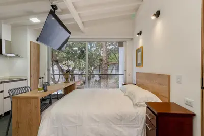 a bedroom with a bed and a desk and a television at Contablers in Medellín