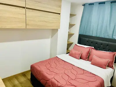 a bedroom with a bed with pink pillows at Torre Meraki in Medellín
