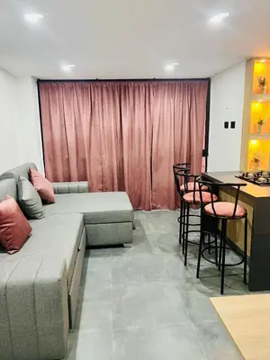 a living room with a couch and a table and chairs at Torre Meraki in Medellín