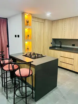 a kitchen with a island with stools and a stove at Torre Meraki in Medellín