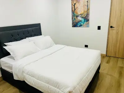 a white bed with a black headboard in a bedroom at Torre Meraki in Medellín