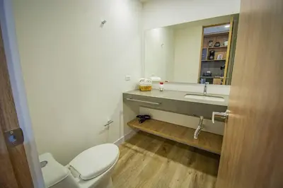 a bathroom with a toilet and a sink and a mirror at TOP FLOOR Studio Poblado, A/C, Coworking, gym 1416 in Medellín