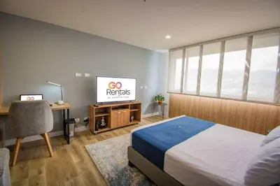 a bedroom with a bed and a tv and a desk at TOP FLOOR Studio Poblado, A/C, Coworking, gym 1416 in Medellín