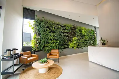 a room with a green wall with a table and chairs at Bright Studio Topfloor A/C, Poblado Coworking1412 in Medellín