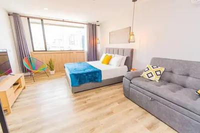 a living room with a bed and a couch at Poblado, Modern studio, coworking, A/C, Gym 1411 in Medellín