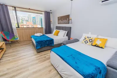 a living room with two beds and a couch at Poblado, Modern studio, coworking, A/C, Gym 1411 in Medellín