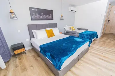 a bedroom with two beds and a tv at Poblado, Modern studio, coworking, A/C, Gym 1411 in Medellín