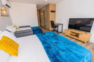 a bedroom with a large bed and a flat screen tv at Poblado, Modern studio, coworking, A/C, Gym 1411 in Medellín
