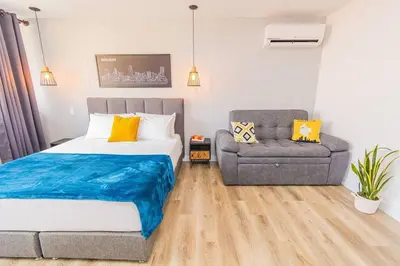 a bedroom with a bed and a couch and a chair at Poblado, Modern studio, coworking, A/C, Gym 1411 in Medellín