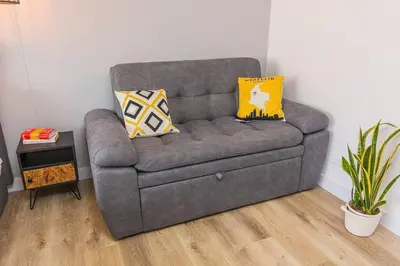 a grey couch with two pillows in a living room at Poblado, Modern studio, coworking, A/C, Gym 1411 in Medellín