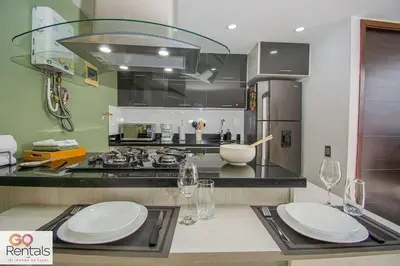 a kitchen with two white plates on a counter at Cozy studio in Poblado, parking, NO FEE 1107 in Medellín