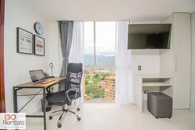 a office with a desk and a chair and a window at Cozy studio in Poblado, parking, NO FEE 1107 in Medellín