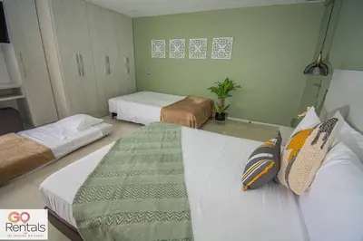 a hotel room with two beds and a couch at Cozy studio in Poblado, parking, NO FEE 1107 in Medellín