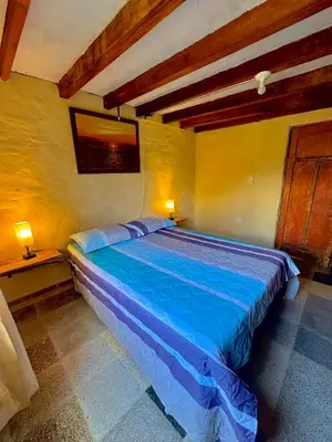 a bedroom with a blue bed in a room at Wayra Ecolodge in El Peñol