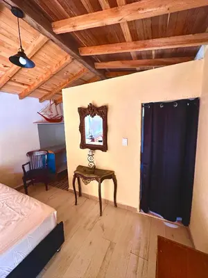 a bedroom with a bed and a table and a mirror at Wayra Ecolodge in El Peñol