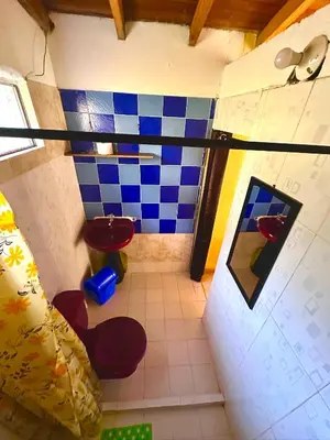 a small bathroom with a blue and white tiled floor at Wayra Ecolodge in El Peñol
