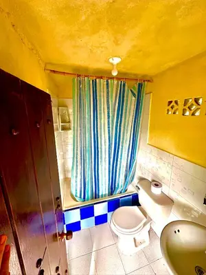 a small bathroom with a toilet and a curtain at Wayra Ecolodge in El Peñol
