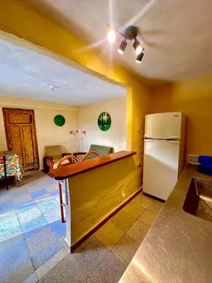 a kitchen with a counter and a refrigerator at Wayra Ecolodge in El Peñol