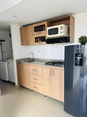 a kitchen with a stainless steel refrigerator and a microwave at Grandioso apartaestudio muy cerca a Provenza 201 in Medellín