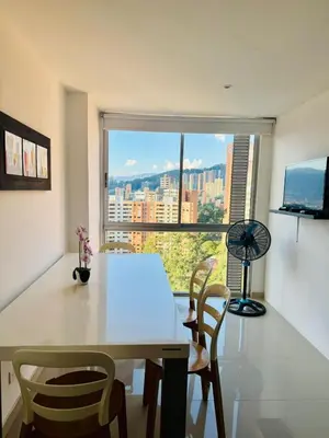 a dining room with a table and chairs and a window at Grandioso apartaestudio muy cerca a Provenza 201 in Medellín