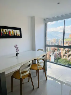 a white table with two chairs and a large window at Grandioso apartaestudio muy cerca a Provenza 201 in Medellín