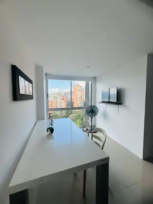 a white room with a table and a large window at Grandioso apartaestudio muy cerca a Provenza 201 in Medellín