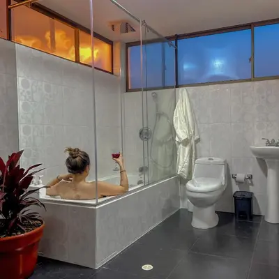 a woman in a bath tub in a bathroom at Apartamento con tina para tu relax! Prime location in Manizales