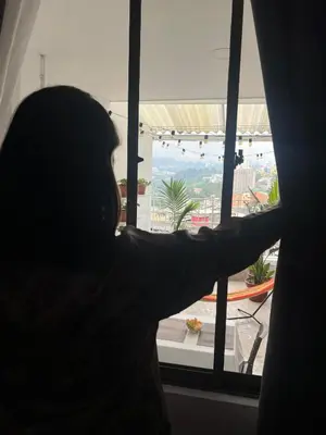 a person is looking out of a window at Apartamento con tina para tu relax! Prime location in Manizales