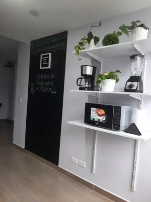 a kitchen with white shelves and a microwave at Apartamento con tina para tu relax! Prime location in Manizales