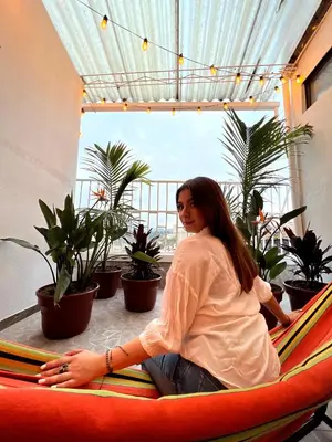 a woman sitting in a hammock in a room with plants at Apartamento con tina para tu relax! Prime location in Manizales