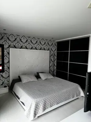 a bedroom with a white bed with a large headboard at Blux 1305 Poblado Medellín Colombia in Medellín