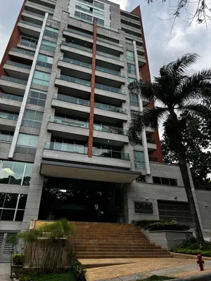 a building with a palm tree in front of it at Blux 1305 Poblado Medellín Colombia in Medellín