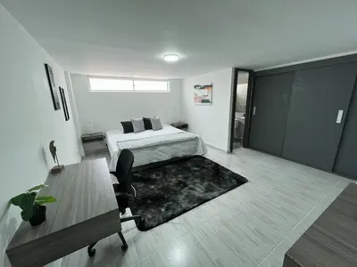 a bedroom with a bed and a desk and a table at Comodo y amplio apartamento en Laureles in Medellín