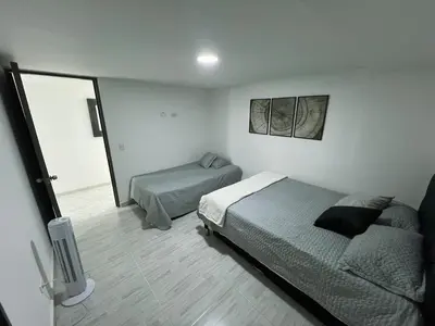a bedroom with a bed and a window and a television at Comodo y amplio apartamento en Laureles in Medellín