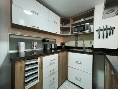 a kitchen with white cabinets and a black counter top at Comodo y amplio apartamento en Laureles in Medellín