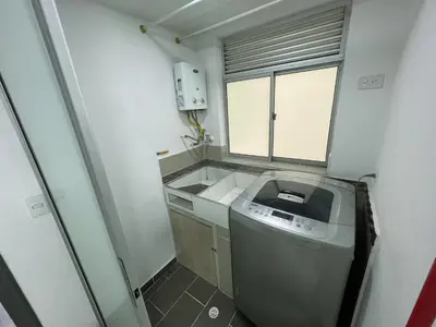 a small kitchen with a washing machine and a window at Comodo y amplio apartamento en Laureles in Medellín