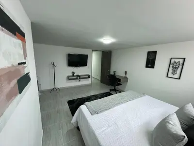 a bedroom with a bed and a flat screen tv at Comodo y amplio apartamento en Laureles in Medellín