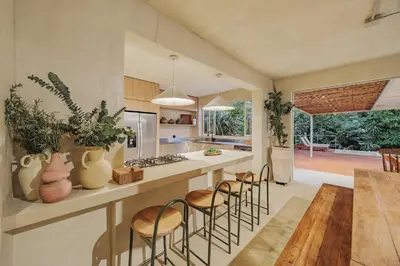 a kitchen with a counter with chairs and a table at Casa Selva, a unique luxury house in the heart of El Poblado in Medellín