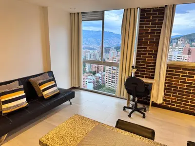 a living room with a black couch and a large window at 2211 Despierta en poblado Medellín - Vista panorámica in Medellín