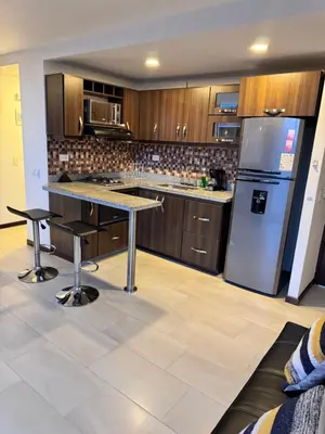 a kitchen with a refrigerator and a table in it at 2211 Despierta en poblado Medellín - Vista panorámica in Medellín
