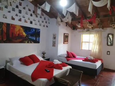 two beds in a room with red pillows on them at Libélula finca-hotel in Concepción