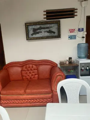 a red leather couch sitting in a living room at Hotel Casa Azul in Sonsón