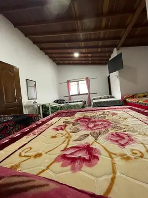 a bedroom with a large bed with flowers on it at Hotel Casa Azul in Sonsón