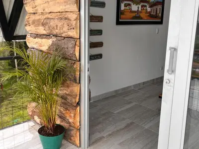 a door with a plant next to a stone wall at Hotel Chalet en montaña Manizales in Villamaría