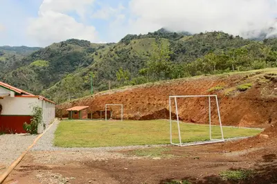 a soccer field with a goal in front of a mountain at Finca Hotel Isla del Encanto in Támesis