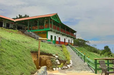 a house on the side of a hill with a building at Finca Hotel Isla del Encanto in Támesis
