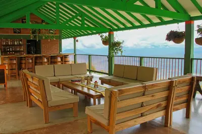 a patio with tables and chairs and a bar at Finca Hotel Isla del Encanto in Támesis